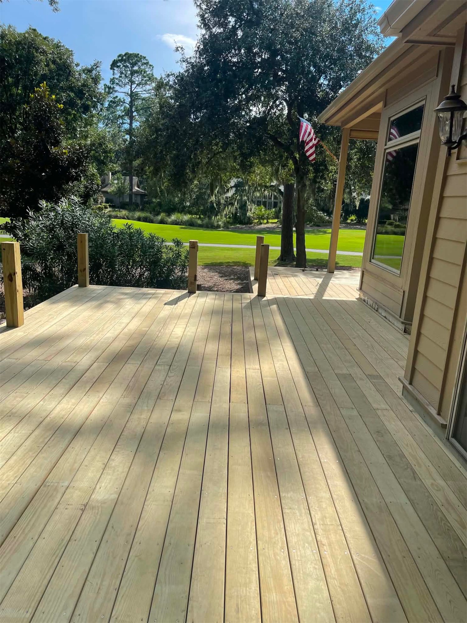 Wood deck boards and railing along the side of a house