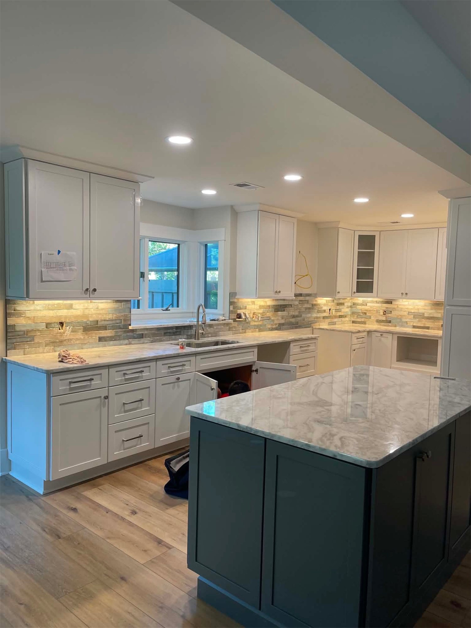 Completed kitchen with light cabinets, an island, and contrasting lower cabinets